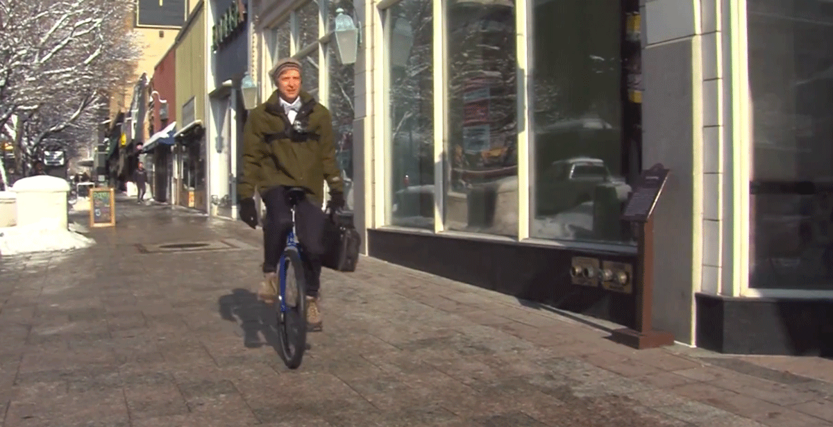 Richard Terry in sella al suo monociclo mentre pedala per andare al lavoro