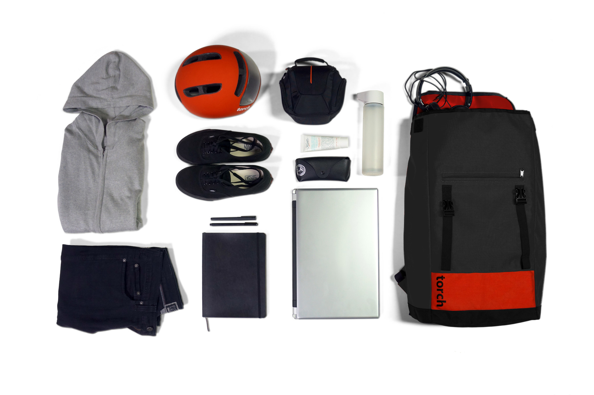 Lo zaino Flux Backpack circondato dagli oggetti che può contenere