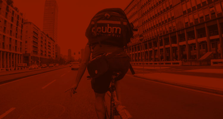 Un bike messenger pedala per le strade di Milano