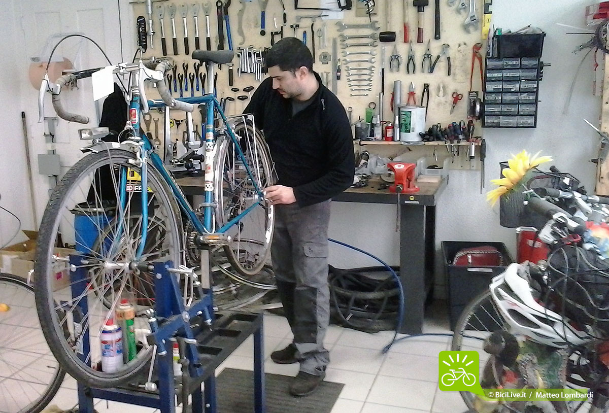 Daniele al lavoro su una bicicletta all'interno della sua ciclofficina