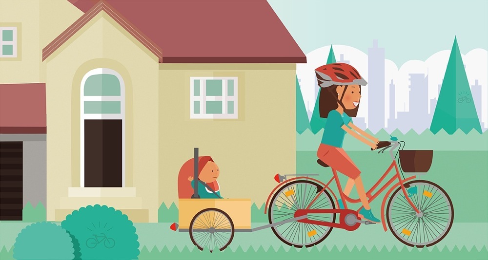 Trasportare bimbi in bici: L'immagine mostra una mamma con carrello da bici con sopra il proprio bambino nel seggiolino da auto