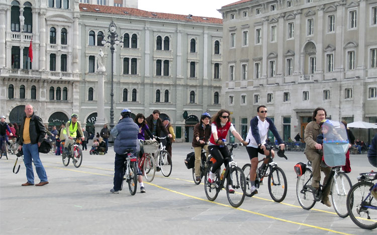 Una immagine di ciclisti che si spostano per la città, felici e sani, nell'aria pulita