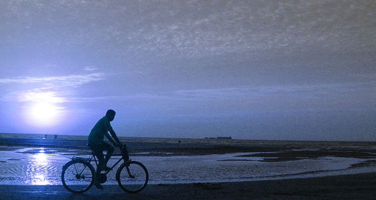 Un ciclista pedala al tramonto, la sua salute migliora