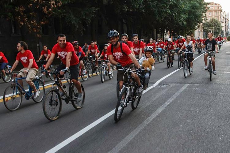 ciclisti percorrono le strade della città durante la sunrise bike ride