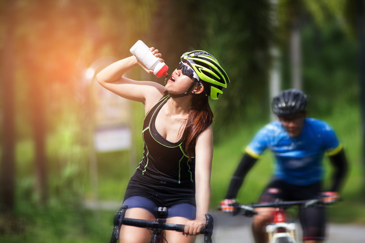 ciclista si idrata per prevenire i crampi