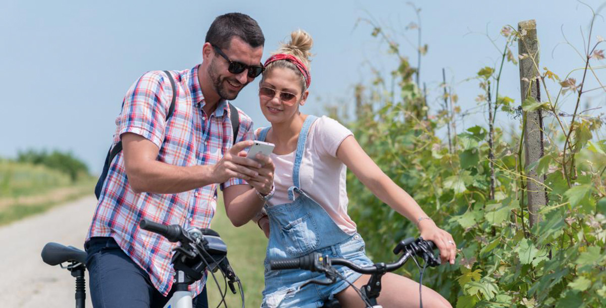 Una coppia in bici nella campagna controlla il percorso sull'app Bikesquare