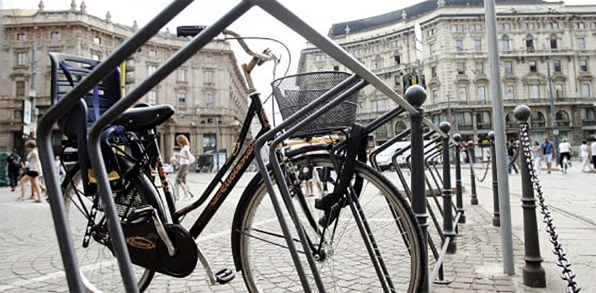 Una bici inserita in una rastrelliera in un centro urbano