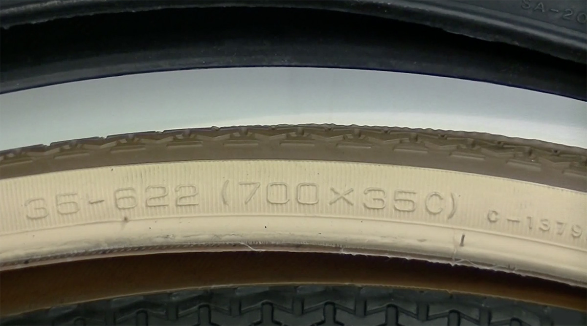 Dettaglio delle dimensioni scritte in diversi formati su un pneumatico di bici