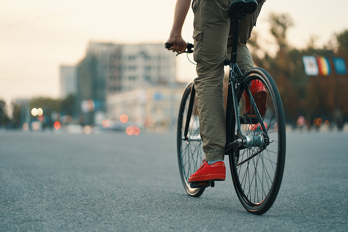 Un uomo pedala in città con una bicicletta urban