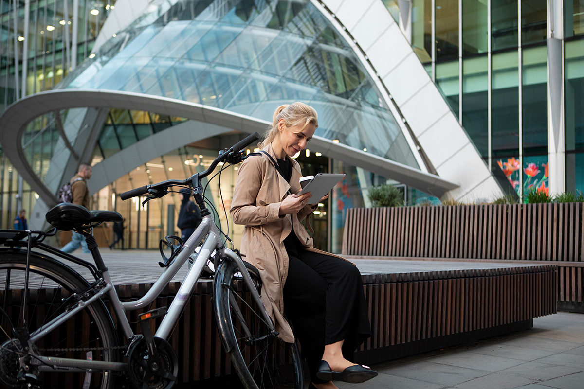 Una donna in bici mentre lavora con il tablet