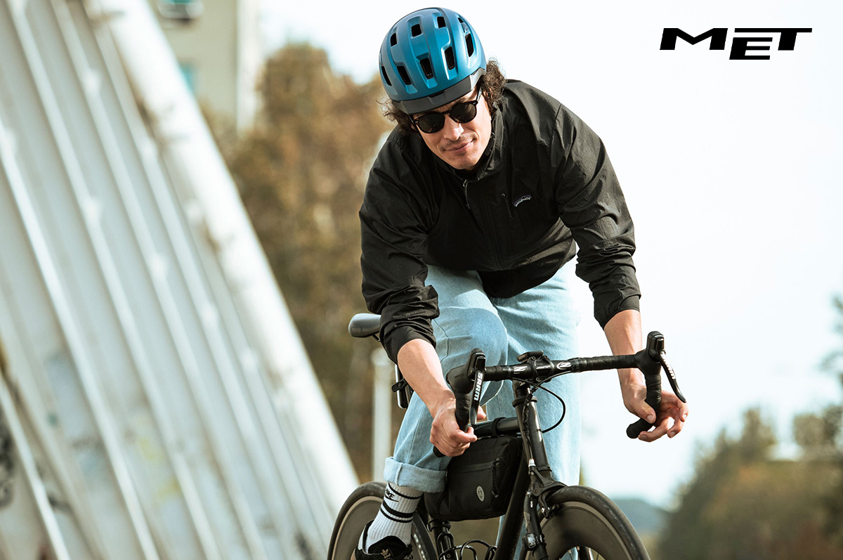 Un uomo pedala su una bici da strada indossando un nuovo casco urban MET 2022