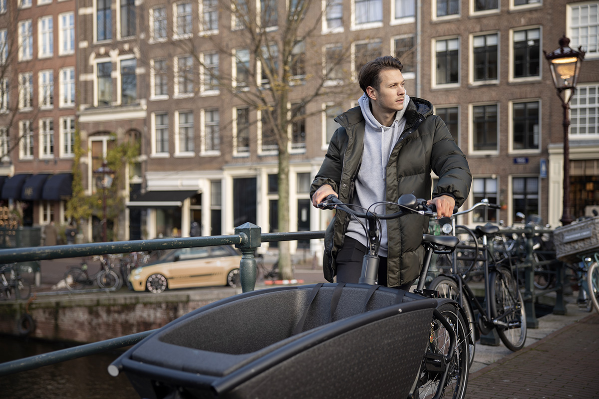 Un uomo si sposta in città con una cargo bike