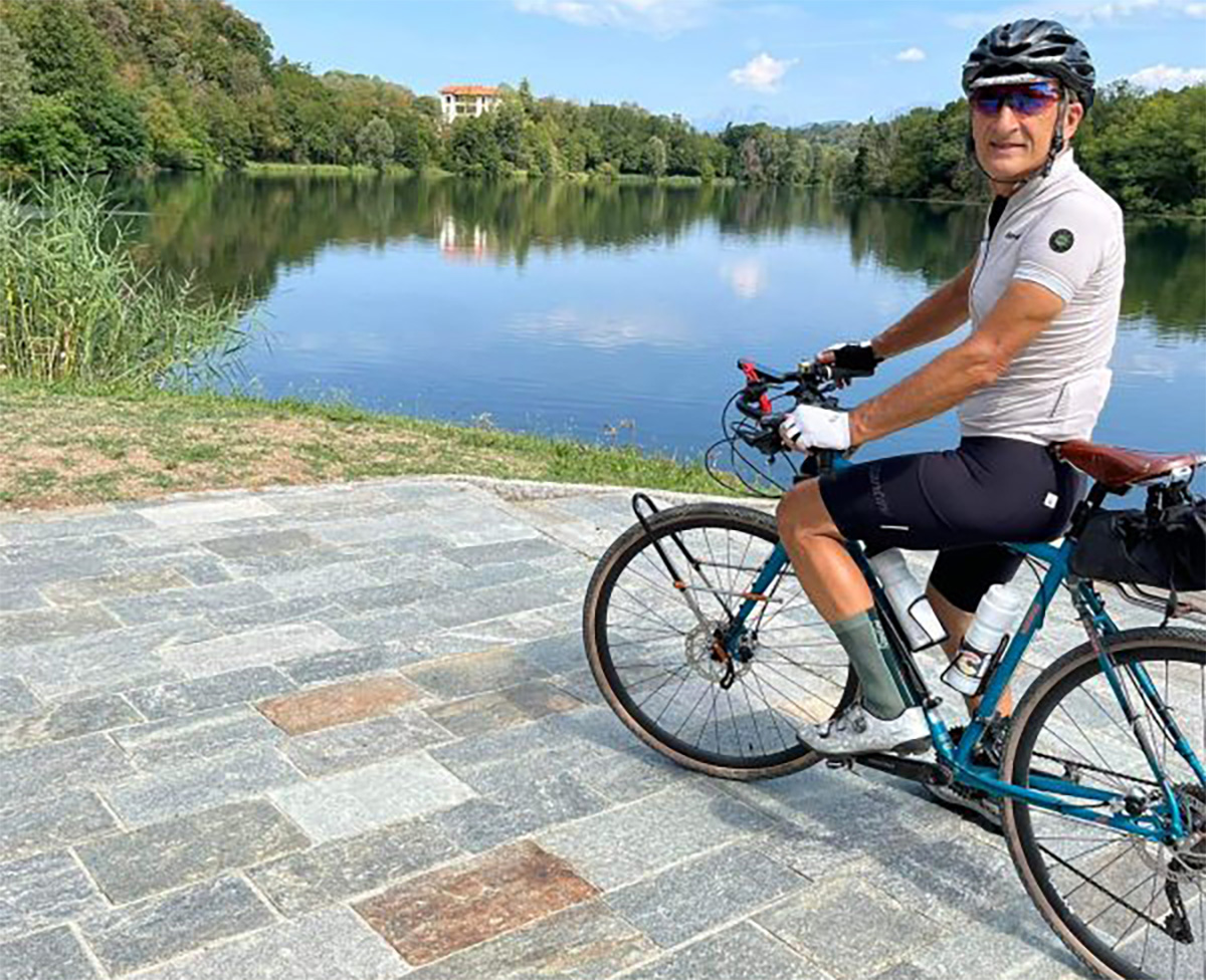 Roberto Peia fermo davanti a un fiume con la sua bicicletta