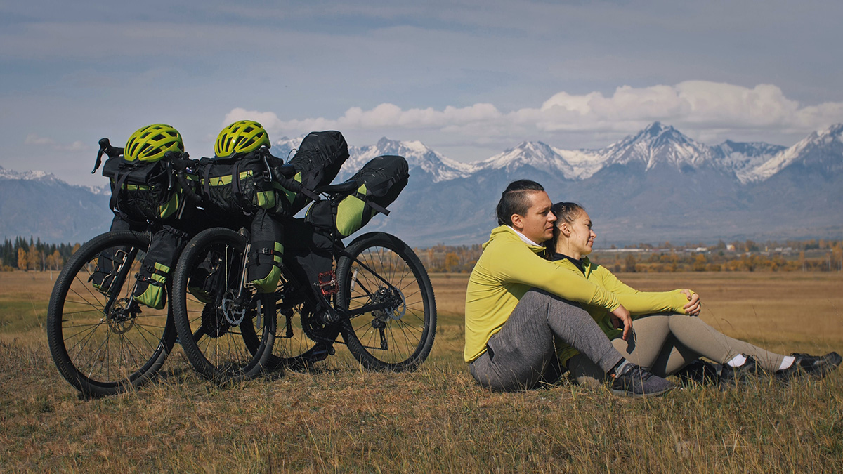 Una coppia di cicloturisti riposa su un prato
