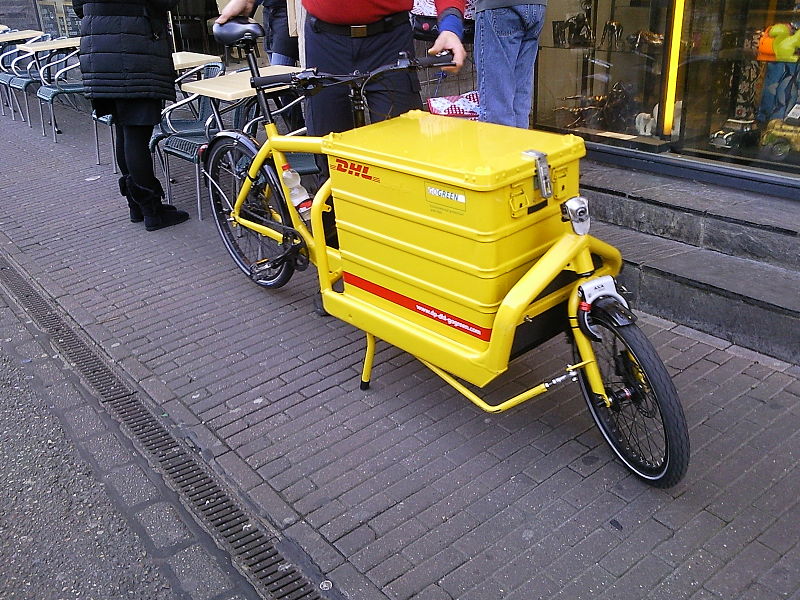 Un corriere DHL di Amsterdam in sella a una bici cargo